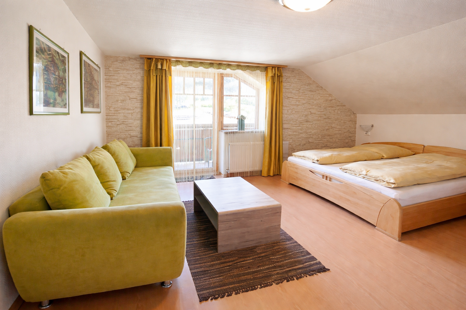 Zimmeransicht im Appartement 6 im Landhaus am Hügel mit Doppelbett, Sitzmöglichkeit und Balkon